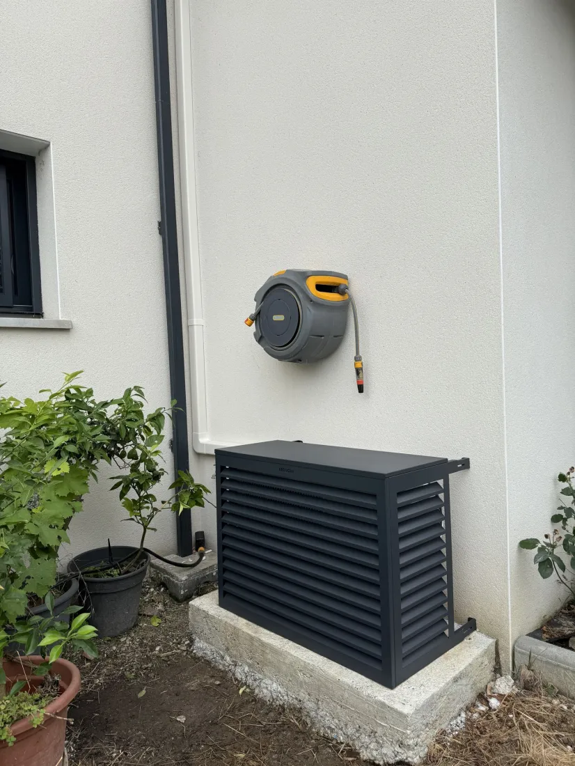 Groupe extérieur de climatisation réversible installé sur lit de galets par Pituello