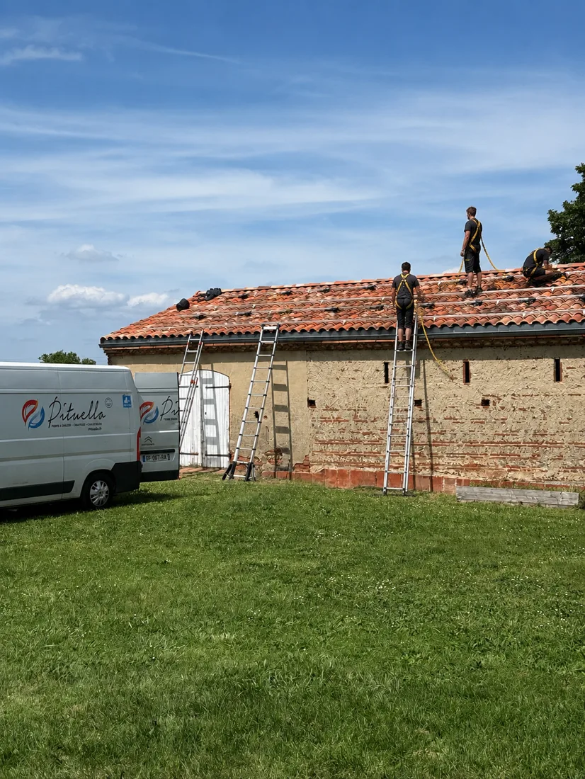 Techniciens Pituello posant des panneaux photovoltaïques sur la toiture d'une grange