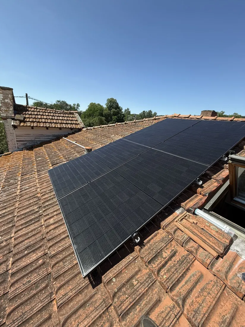 Panneaux solaires intégrés sur la toiture d'une maison ancienne