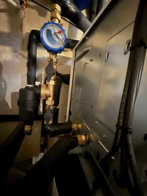 Kit hydraulique d'une pompe à chaleur air-eau à Venerque : tuyauteries noires calorifugées, vannes et raccords en laiton